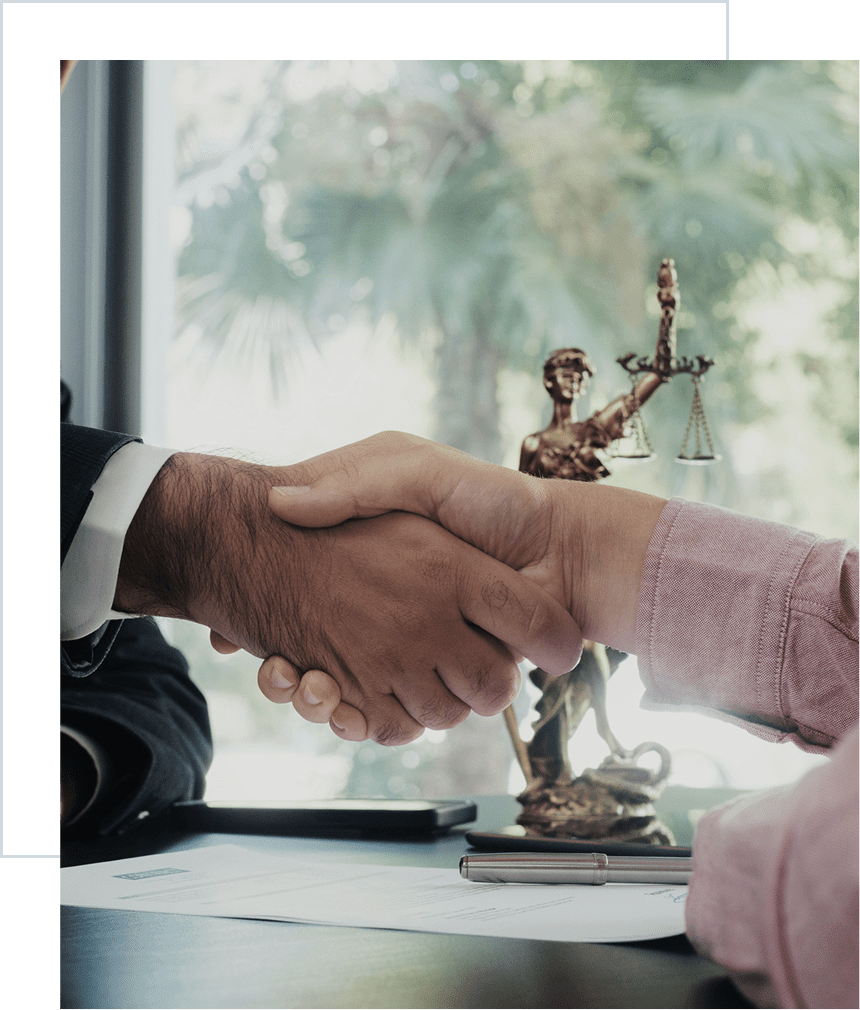 Business handshake with justice statue